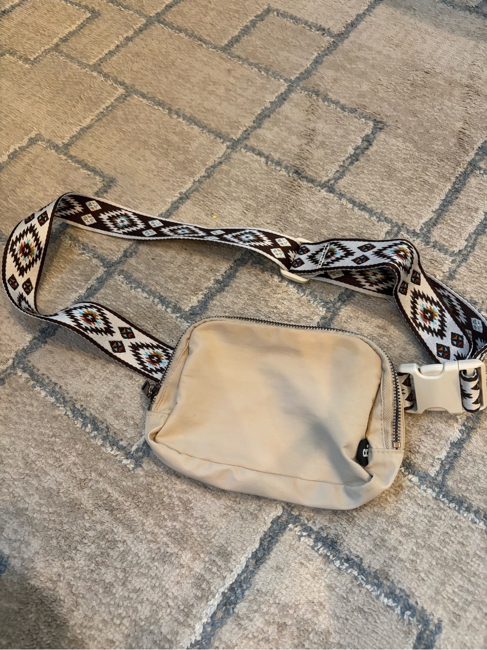 C.C brand beige belt bag featuring a southwestern patterned adjustable strap